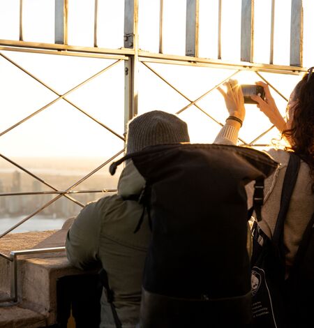 Des personnes contemplent la vue depuis l'observatoire du 86e étage de l'Empire State Building.